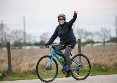 Vibrant cyclist riding Bluebonnet Express bike in outdoor park, promoting active lifestyle and cycling fitness.