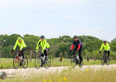 Bright yellow cyclists' jackets on a scenic bike ride with Bluebonnet Express branding.