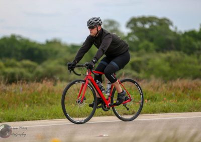 Bike rider on a red bicycle in a scenic outdoor setting for Bluebonnet Express SEO imagery.