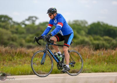 Vegan cyclist riding on scenic rural road, promoting healthy biking lifestyle.