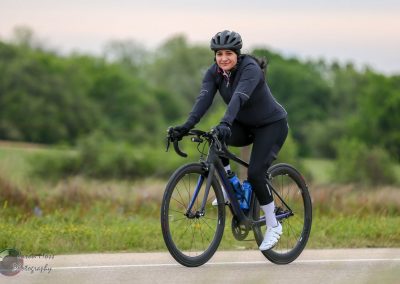 Bike rider on EV bike, cycling outdoors on a scenic trail in Texas, promoting Bluebonnet Express bike routes.