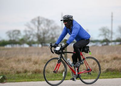 Vegan cyclist riding a red Cannondale bike on open trail in outdoor setting.