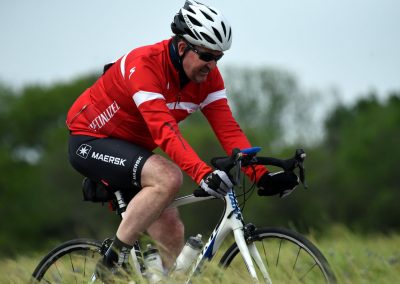 Vibrant cyclist riding on a mountain trail in Green fields, showcasing adventure biking.
