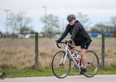 Vibrant cyclist enjoying a ride on the Bluebonnet Express bike trail on a cloudy day.