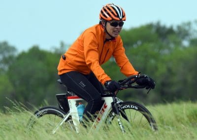 High-performance cyclist riding a bike on a grassy trail outdoors.
