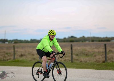 Bright green cycling jacket and helmet worn by rider on the Bluebonnet Express bike trail, enjoying outdoor cycling.