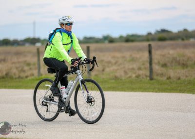 Vegan cyclist riding on a scenic countryside bike trail, highlighting Bluebonnet Express biking event.
