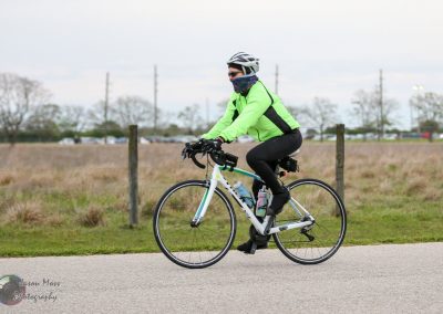 High-visibility cyclist riding a bike on scenic outdoor trail, promoting safe biking adventures.