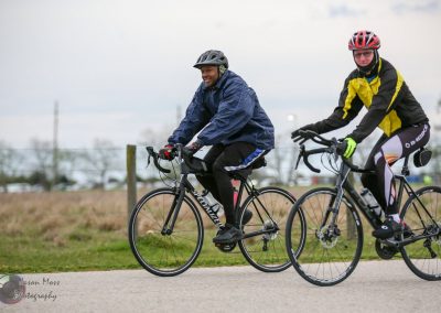 Brightly dressed cyclists riding bicycles outdoors, promoting Bluebonnet Express bike programs and sustainable transportation.