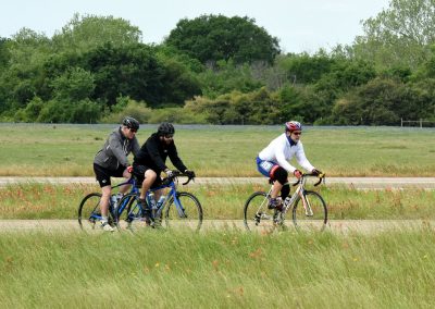 Riders cycling in scenic outdoor trail in Texas, promoting eco-friendly transportation and fitness.