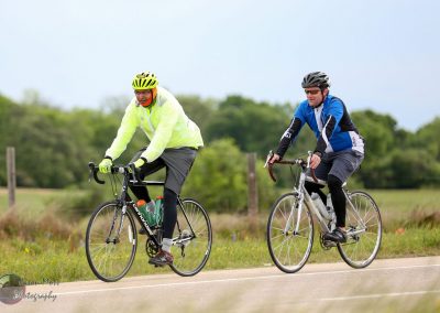 Brightly dressed cyclists enjoying a scenic ride on the Bluebonnet Express trail, showcasing outdoor biking adventure and health.