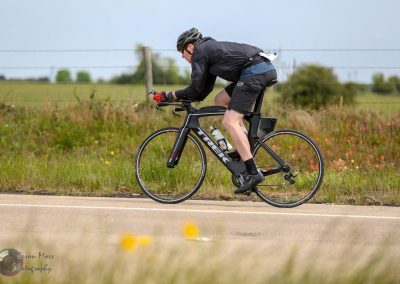 High-performance electric bike riding through open countryside on a clear day.