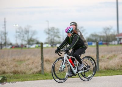 Enjoying scenic bike ride on Bluebonnet Express trail with safety helmets and outdoor gear.
