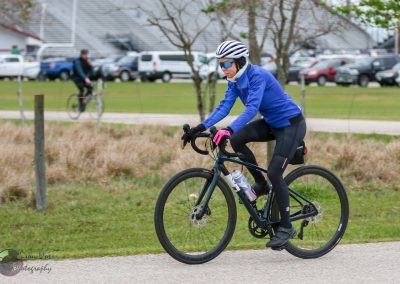 High-performance cyclist on electric bike in green park, Bluebonnet Express, eco-friendly transportation, outdoor biking fun.