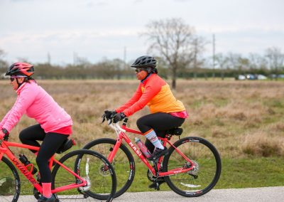 Brightly dressed cyclists enjoying a scenic ride on Bluebonnet Express trail in Texas.