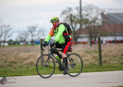 Brightly dressed cyclist riding a bike on the trail during daytime, gear for outdoor cycling adventure.