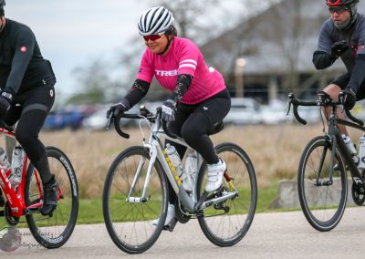 Bright pink cyclist jersey, bike ride on scenic trail, outdoor cycling event, Bluebonnet Express race, healthy active lifestyle, cycling adventure.