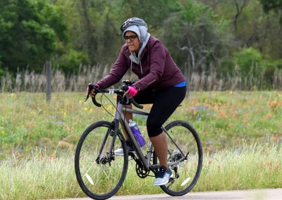 Vintage electric bike riding through wildflower meadow on scenic trail.