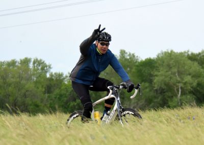 Velo cyclist on grassy trail during daytime, promoting outdoor biking adventures.