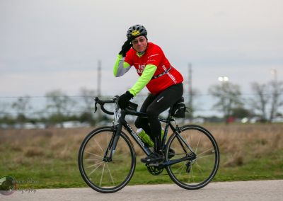 Vegan cyclist riding on green bike, promoting Bluebonnet Express cycling event and healthy lifestyle.