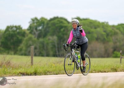 Bright woman cyclist enjoying the scenic Bluebonnet Express trail in Texas, promoting outdoor recreation and bike tourism.