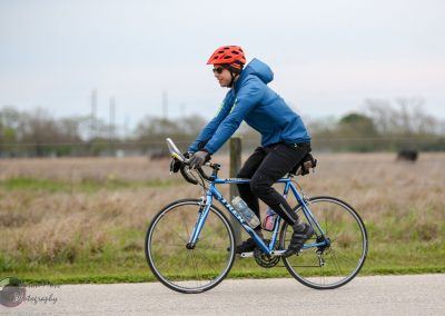 Safe outdoor cycling on a blue bike with rider wearing a red helmet and blue jacket.