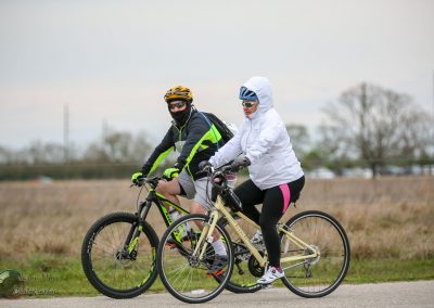 Cyclists riding bikes outdoors during cloudy weather, enjoying a scenic bike ride.