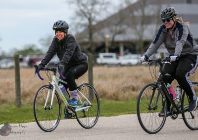 Bright women cycling on Bluebonnet Express bike path, enjoying outdoor exercise and scenic views.