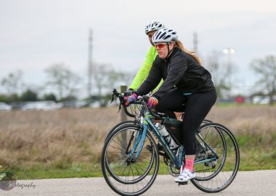 Bike riding outdoors with cyclists dressed in activewear and helmets for safety.