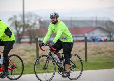 Cyclist in neon green riding a bike during Bluebonnet Express event in Texas.