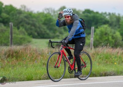 Bright blue and black bike touring gear on a cheerful cyclist riding through scenic countryside.