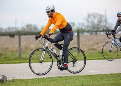 Vibrant cyclist riding on scenic trail with Bluebonnet Express bike in outdoor setting.