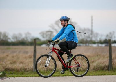 Bright blue biking jersey, rider on red mountain bike enjoying outdoor cycling adventure.