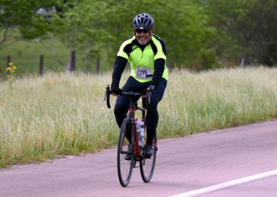 Bright yellow high-visibility cycling jersey for Bluebonnet Express bike race, outdoor event, safety gear, scenic rural trail, active lifestyle, sport ride.