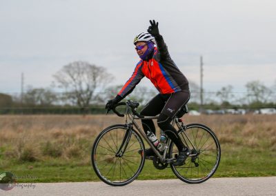 Bright cyclist riding a bike on the road, wearing colorful cycling gear and helmet.