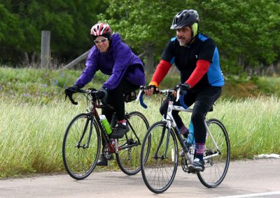 Vibrant cyclists riding bikes on scenic trail during daytime for outdoor adventure.