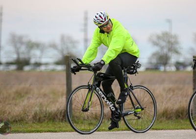 Bright yellow cyclist jacket on professional gravel bike for optimal visibility.