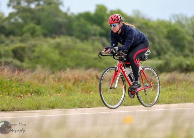 Energetic cyclist riding a red bike along a scenic outdoor trail.