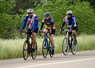 High-energy cyclists riding together on a scenic outdoor trail, showcasing Bluebonnet Express bike tours and cycling adventures.