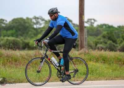 Cyclist riding a Trek road bike outdoors on a scenic trail in Texas.