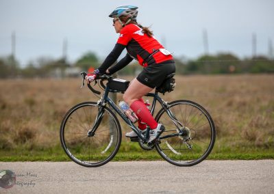 Cyclist riding a Bluebonnet Express bike on a scenic trail during daytime in Texas.