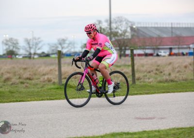 Bright pink cycling jersey and shorts on female cyclist riding Bluebonnet Express trail.