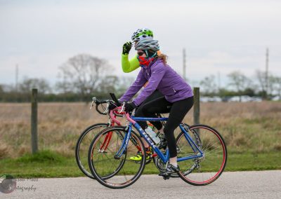 Vegan cyclist riding on a scenic trail, dressed in vibrant gear, promoting outdoor activity and healthy lifestyle.