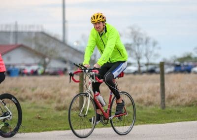 Bright yellow cycling jacket on male cyclist riding a bike during Bluebonnet Express event.
