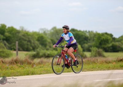 Bright woman cycling along scenic outdoor trail on a mountain bike, enjoying nature and fitness.