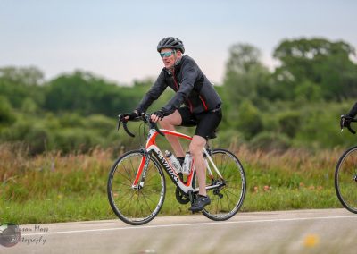 Bright male cyclist riding a bike on scenic outdoor trail during daytime for Bluebonnet Express event.