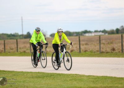 Brightly colored cyclists riding on scenic route in Texas for Bluebonnet Express.