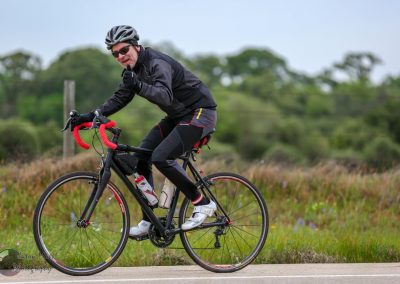 Vegan cyclist riding on scenic road, promoting eco-friendly exercise and sustainable transportation.