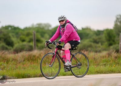 Colorful cyclist enjoying multi-terrain ride in scenic outdoor landscape.