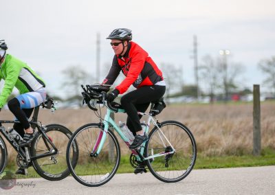 Bright cyclist riding a bike on a scenic outdoor trail during daytime.